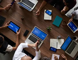 Vergadering met laptops en telefoons